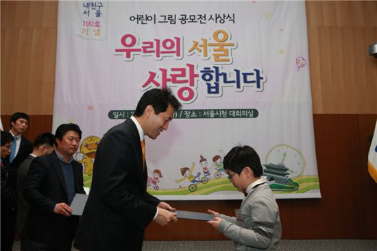 오세훈 서울시장(왼쪽)이 '내가 사랑하는 서울 어린이 그림 공모전' 시상식에서 대상을 받은 강연욱 이대부속초 3학년 어린이에게 상장을 주고 있다. 

