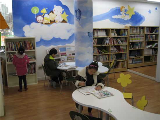 초등학생들이 어린이 작은도서관에서 책을 보고 있다.