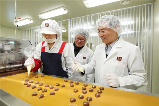 정기석 롯데월드 대표(오른쪽)가 20일 협력업체 선영제과의 초콜릿 생산라인을 방문해 초콜릿 만들기 체험을 하고 있다.