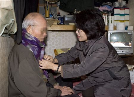 진수희 보건복지부 장관이 20일 서울 중구의 한 쪽방촌을 찾아, 쪽방 거주민에게 목도리와 내의를 전달하고 있다. -사진제공: 보건복지부-