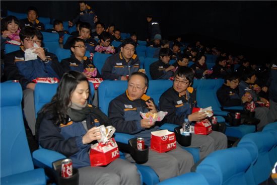 정광석 성동조선해양 사장(왼쪽에서 두번째)과 인턴직원들이 지난 26일 회사 인근 롯데시네마에서 음식을 먹으며 영화를 관람하고 있다.