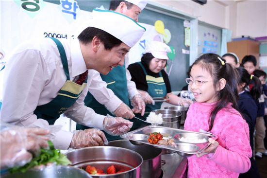 강동구는 2009년 3월 2일 위례초등학교에서 첫 친환경 학교 급식을 실시했다. 이해식 강동구청장이 당일 어린이에게 배식을 하고 있다.