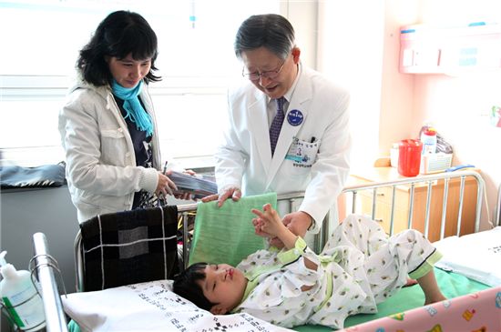 김성덕 중앙대학교 병원 원장(오른쪽)이 베트남 구개열 환자를 돌보고 있다.