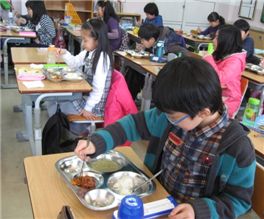 '무상급식'이 본격 시행된 지 이틀 째인 지난 3일 서울 용산구 산천동 원효초등학교 4학년 2반 학생들이 교실에서 배식을 받아 점심식사를 하고 있다.