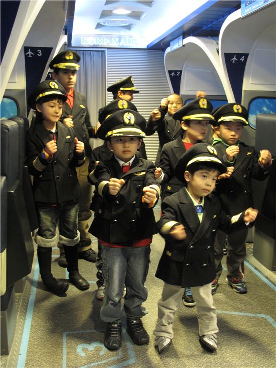 다문화 가정 어린이 초청 행사에 참여한 어린이들이 대한항공 조종사 복장을 입고 포즈를 취하고 있다. 

