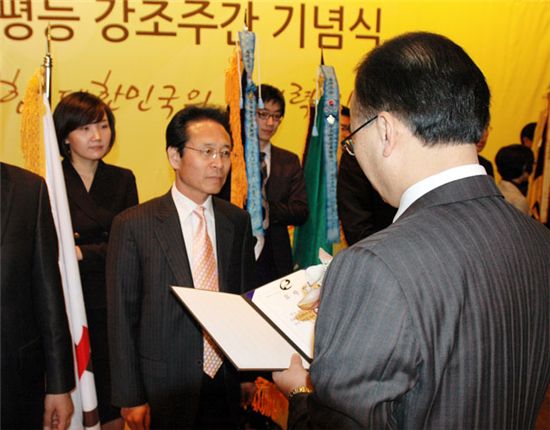 곽동석 ktcs 경영기획실장(가운데)이 박재완 고용노동부장관으로부터 표창장을 받기 위해 서있다.