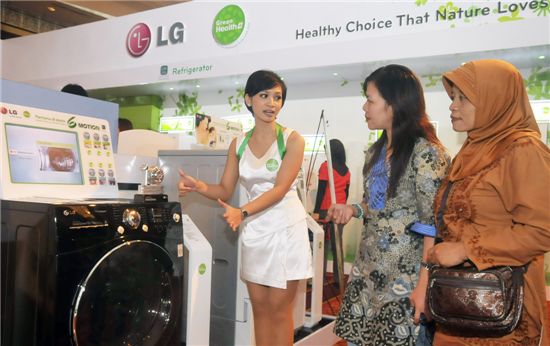 11일 인도네시아 자카르타에서 열린 LG전자의 '그린 헬스 플러스 캠페인'에서 행사 도우미가 현지 기자단에게 친환경 신제품 세탁기를 설명하고 있다.

