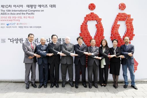 (왼쪽부터) 이인규 커뮤니티 위원장, 프라사다라오 UNAIDS 특별고문, 조명환 조직위원장, 자히드 ASAP 회장, 신승일 행사전시위원장, 손애리 학술프로그램위원, 안젤라 강주현 국제협력위원장, 김병기 공동조직위원장이 6688개의 콘돔으로 만든 레드리본월 앞에서 포즈를 취하고 있다.(사진제공=제10차 아시아태평양 에이즈대회 조직위원회)