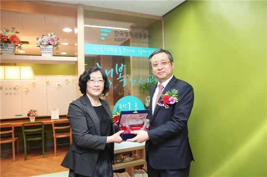 유재한 한국정책금융공사 사장(오른쪽)이 행복도서관 개설 직후 동천요양원 이혜순 원장에게 감사패를 받고 있다. 
 