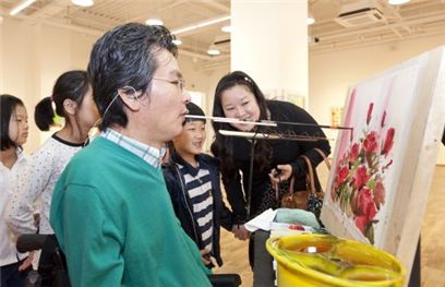 19일 경기도 분당 암웨이갤러리 개관 특별전을 기념해 이호식 구필화가가 어린이들에게 꽃 그림을 시연해 보이고 있다.