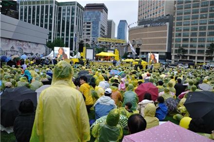 고 노무현 전 대통령 서거 2주기를 이틀 앞둔 21일 서울광장에는 빗줄기 속에서도 많은 인파들이 노란 우비를 입고 추모행사에 참여했다.
