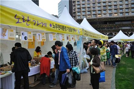 고 노무현 전 대통령 서거 2주기를 이틀 앞둔 21일 서울광장에는 빗줄기 속에서도 많은 인파들이 노란 우비를 입고 추모행사에 참여했다.