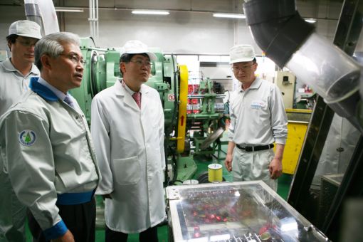 이재혁 롯데칠성 대표(가운데)가 석호영 삼화왕관 대표(왼쪽)로부터 이중 캡 생산라인에 대한 설명을 듣고 있다.