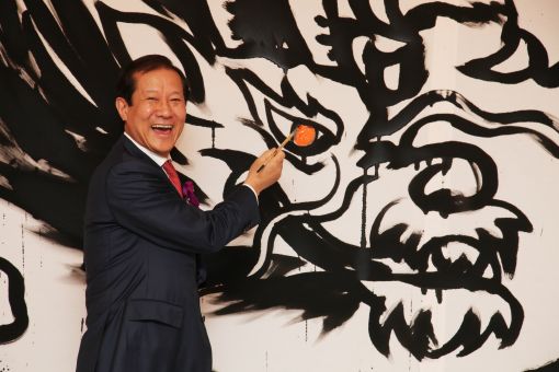 서울 웨스틴조선호텔의 최홍성 대표가 그랜드오프닝 기념 행사에서 용 그림에 눈을 그리며 화룡점정을 찍고 있다.