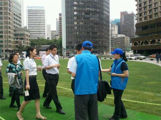 1일 서울광장, 청계광장, 광화문 광장 등 세곳에서 본격적인 흡연 단속이 실시된 첫 날. 파란 조끼를 입은 공무원들이 점심시간 시민들에게 캠페인 내용이 담긴 부채를 전하며 설명하고 있다.