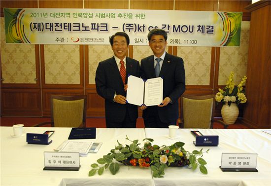김우식(왼쪽) ktcs 대표이사 부회장이 박준병 대전테크노파크 원장과 협약서를 펼쳐보이고 있다. 