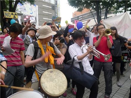 11일 오후 4시께 일본 도쿄도 신주쿠구 도쿄도청 앞 광장에서 6.11 탈원전 집회를 벌였던 시민들이 신주쿠 알타빌딩 앞 광장까지 시가행진을 한 뒤 북과 드럼, 트럼팻 등을 연주하며 시위하는 모습.