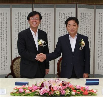 이길구 사장(왼쪽)과 김용진 한국동서발전노동조합 위원장이 임단협과 필수유지업무협정(조합원 100% 지정)에 서명한 수 악수하고 있다. 