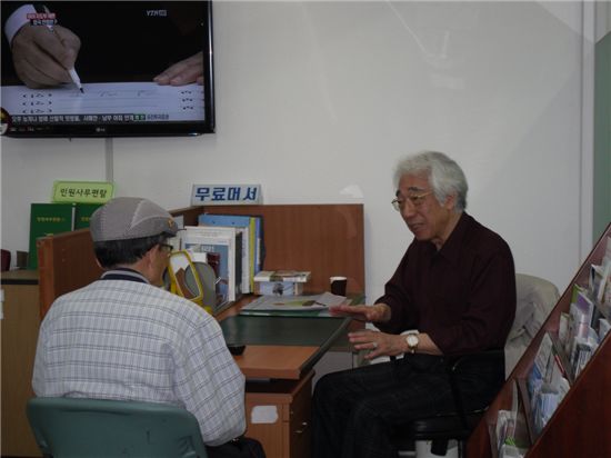 명륜3가동 민원상담관으로 일하고 있는 홍재창씨가 상담을 하고 있다.