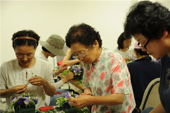 식물교실에서 꽃을 다듬고 있는 수강생들.