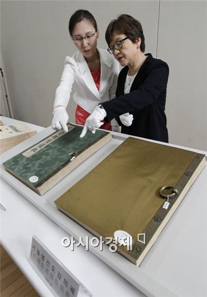 프랑스에서 145년 만에 돌아온 외규장각 의궤가 처음으로 공개됐다. 유새롬 국립중앙박물관 연구기획실 학예연구사(왼쪽)와 김영나 국립중앙박물관장(오른쪽)이 '장렬왕후존숭도감의궤'를 살펴보고 있다. 