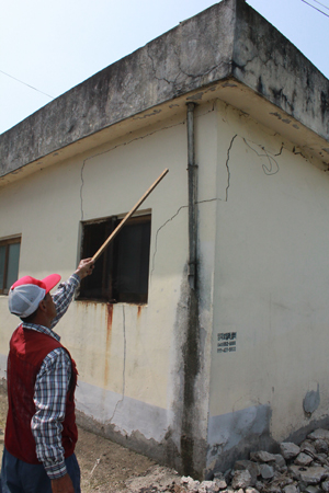 마을주민 현대순씨가 자신의 집 창고에 갈라진 부분을 보여주고 있다.