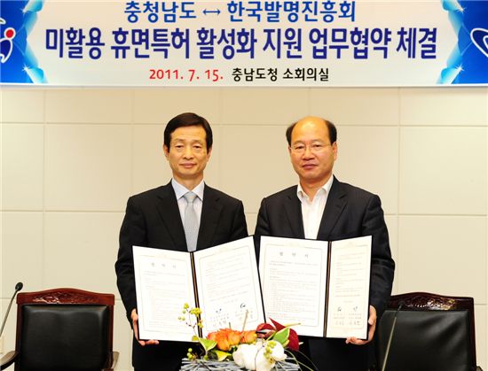 최종협(왼쪽) 한국발명진흥회 회장 직무대행과 구본충 충남 행정부지사가 협약서를 펼쳐보이고 있다.
