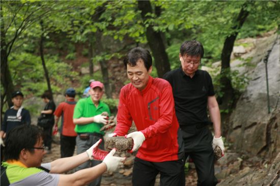 박겸수 강북구청장이 북한산 돌쌓기 행사에 참석해 돌을 나르고 있다.
