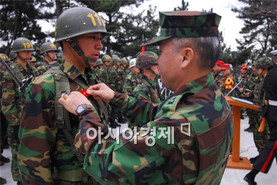 이해승(준장) 해병대교육훈련단장이 18일 신병교육을 수료한 1111기 병사에게 빨간 명찰을 수여하고 있다. 