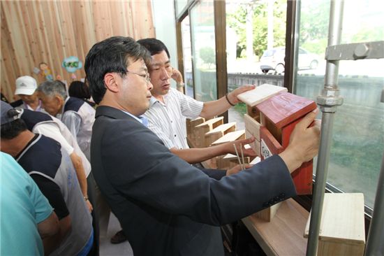 김우영 은평구청장이 목제품을 살펴보고 있다.