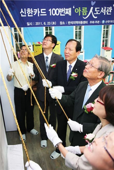 6월 23일 고양시 행신동 반석지역아동센터에서 열린 신한카드 100번째 아름인도서관 개관식에서 참석한 관계자들이 현판을 제막하고 있다. 