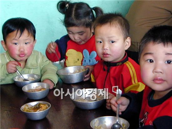 부실한 식단으로 끼니를 때우고 있는 북한 어린이들의 모습.