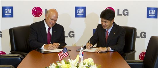 24일(미국 시간) 미국 디트로이트 GM 본사에서 열린 '전기차 공동 개발 협약 체결식'에서 댄 애커슨 GM 회장 겸 최고경영자(왼쪽)와 조준호 ㈜LG 사장(오른쪽)이 협약서에 서명하고 있다. 이번 협약을 통해 GM은 LG와 함께 다양한 전기차 개발 가능성을 열었다.