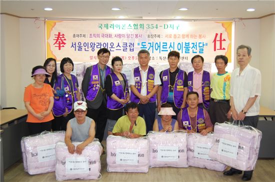 서울인왕라이온스클럽 회원들이 독거어르신들에 이불 50채를 전달했다.