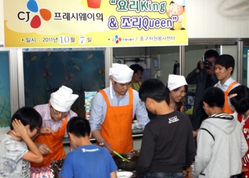 CJ프레시웨이 직원들이 서울 중구 중림동에 위치한 등대 지역안동센터에서 돼지고기 야채 카레, 미니 돈까스, 미소국, 단무지, 치즈 케이크, 딸기 요구르트 등으로 마련된 저녁 식사를 아동들에게 제공하고 있다. 