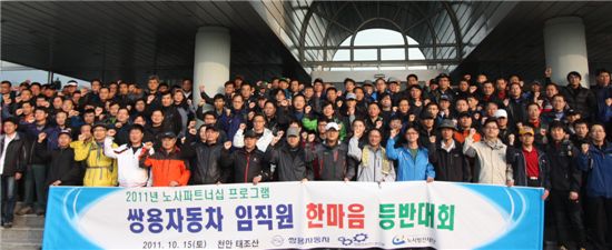이유일 대표이사와 김규한 노조위원장(앞줄 왼쪽 일곱 번째부터)을 비롯한 참가 임직원들이 출발 전 평택 본관 사옥 앞에서 기념촬영하고 있다.
