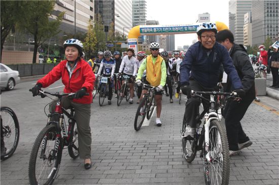 자전거를 타고 있는 진영욱 한국정책금융공사 사장(오른쪽)과 김영선 국민생활체육전국자전거연합회 회장.  