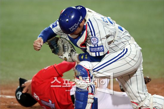 26일 오후 대구 시민야구장에서 `2011 롯데카드 프로야구` 삼성 라이온즈와 SK 와이번스의 한국시리즈 2차전 경기가 열렸다. 8회초 2사 1, 2루에서 SK 최동수의 안타때 2루주자 최정이 홈에서 삼성 진갑용에게 태그아웃되고 있다.(사진=삼성 라이온즈 제공)