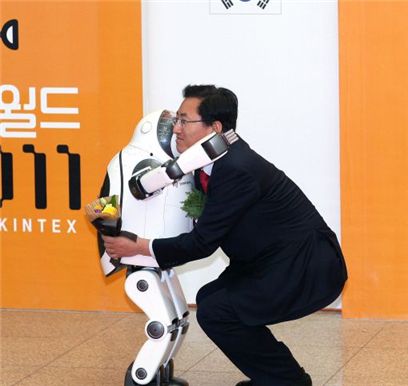 최중경 장관이 이날 첫선을 보인 휴머노이드 로봇 '키보'에게 꽃다발을 받은 뒤 포옹하고 있다