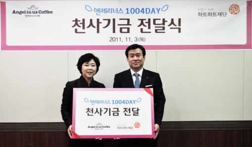 최병규 롯데리아 커피사업부문장이 신인숙 하트하트 재단 이사장에게 천사데이 캠페인을 통해 모금된 기부금을 전달하고 있다.