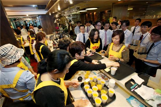 STX 가족봉사단원들이 STX남산타워에서 열린 난치병아동돕기 일일 자선 카페를 찾은 손님들을 맞이하고 있다.