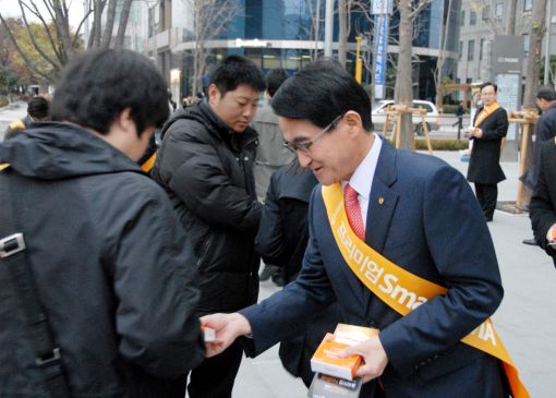 임일수 한화증권 대표(오른쪽)가 16일 오전 여의도에서 출근길 직장인들에게 비타민를 증정하며 자사 CMA 상품을 설명하고 있다. 