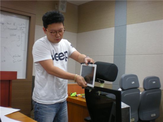 한 학생이 기존에 나온 차량용 디스플레이를 설치하며 문제점을 설명하고 있다.