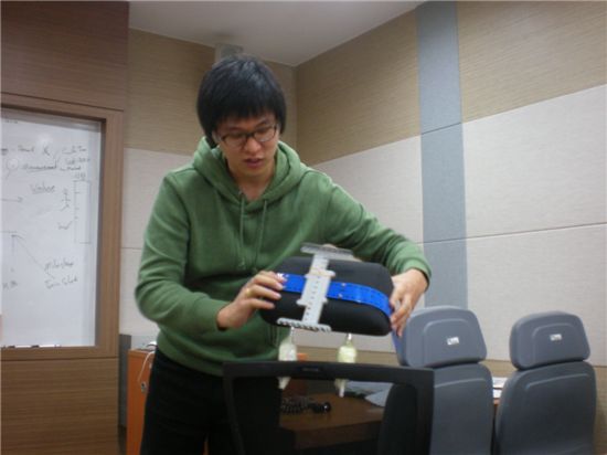 한 학생이 벨트를 이용해 디스플레이 장치를 고정하는 방법을 설명하고 있다.