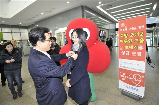 추재엽 양천구청장이 양천구 직원에게 사랑의 열매를 달아주고 있다.