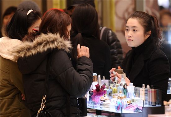 ▲정부의 에너지 절감 대책으로 실내온도를 20℃이하로 낮춘 18일, 서울 소공동 롯데백화점 본점의 화장품 매장에서 한 여성이 두꺼운 외투를 입은채 화장품을 고르고 있다. 매장 직원도 두툼한 옷차림을 하고 있는 모습이다. 같은날 명동의 한 화장품 로드숍에서는 전면 유리창을 모두 열어젖히고, 외부에 전기난로까지 틀고 영업을 해 에너지 절약의 상반된 모습을 보여주고 있다. (사진 양지웅 기자 yangdoo@)