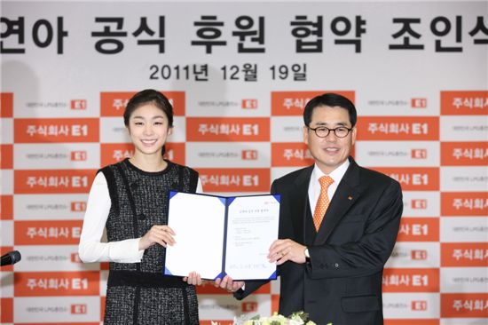 ▲구자용 E1 회장(오른쪽)과 김연아 선수가 19일 공식 후원 협약 조인식에서 조인서를 들고 웃고 있다.