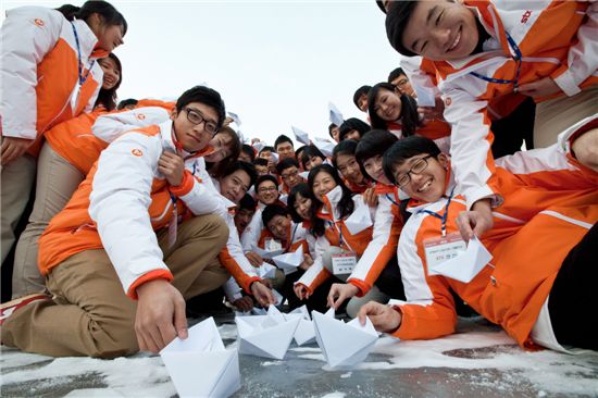 STX그룹 2012년 신입사원들이 각자 포부가 담긴 편지지로 만든 배와 함께 포즈를 취하고 있다.
