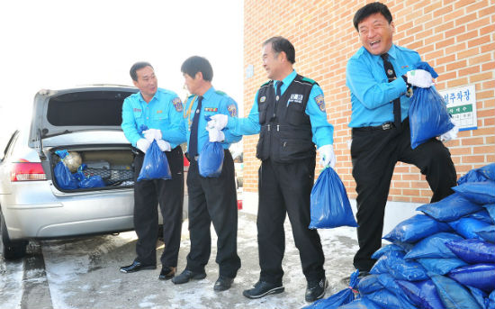 대전시 중구 모범운전자회 회원들이 5일 제설용 모래주머니를 택시에 싣고 있다.