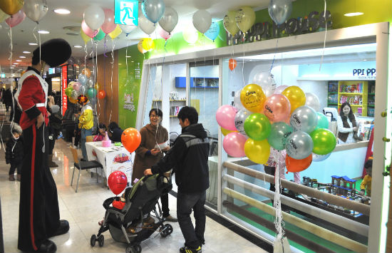 대전롯데백화점이 15일 어린이 교구 놀이방 '삐삐하우스'를 열었다. 아이를 데리고 온 한 부모가 키다리아저씨로부터 풍선을 받고 있다